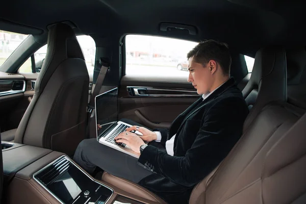 ¡Trabaja duro! Retrato de vista lateral del hombre guapo inteligente impresionante haciendo su negocio en el asiento trasero de su automóvil moderno . — Foto de Stock