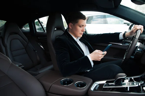 Μην πληκτρολογείτε, κατά την οδήγηση! Μερική άποψη του το όμορφος έξυπνη νεαρή νεοφερμένο μηνυμάτων, ενώ η χρήση του τηλεφώνου και την οδήγηση του αυτοκινήτου. — Φωτογραφία Αρχείου