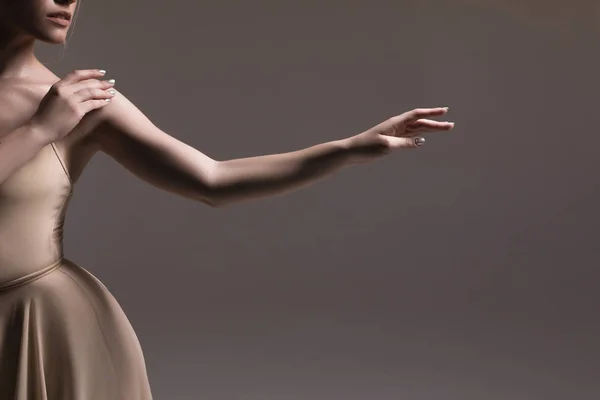 Balla per sempre! Teneri mani della giovane delicata ballerina professionista delicata che balla sullo sfondo beige isolato al chiuso . — Foto Stock