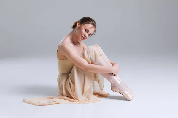 ¡La ternura está adentro! Joven atractiva y elegante bailarina suave sentada en el suelo y posando ante la cámara en el moderno estudio . —  Fotos de Stock