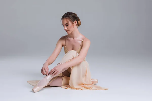 Profitez de votre détente ! Portrait latéral de la jeune ballerine assise sur le sol dans le studio de danse moderne et posant à la caméra . Images De Stock Libres De Droits