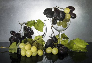 Taze üzüm, yeşil yaprakları ve cam ile natürmort