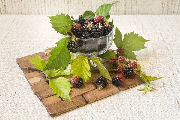 BlackBerry in a glass on the table close-up. blackberries on a wooden background.