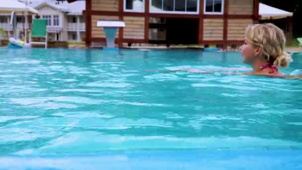 Красива дівчина в бікіні плаває в басейні на відкритому повітрі. Відпочинок в горах Росії. Спа-готель у лісовій зоні. — стокове відео