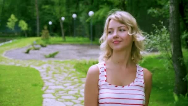 Una bella ragazza bionda sexy passeggia in un parco in una foresta di montagna in vacanza in un hotel termale in Russia. Felice bionda sorridente . — Video Stock