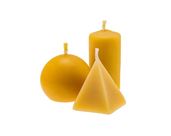 Three golden beeswax candles isolated on white background