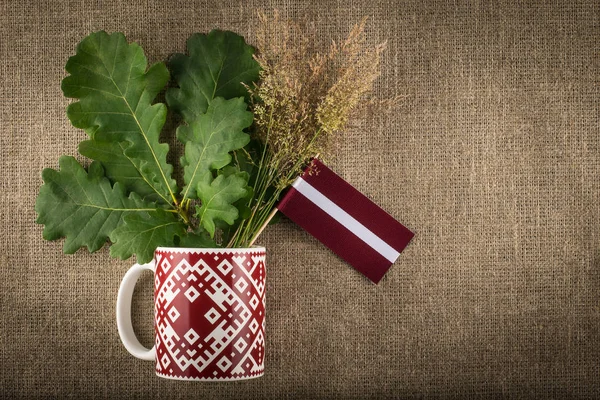 Sammansättning Med Lettiska Flaggan Gren Och Nationella Mönstrad Mugg — Stockfoto