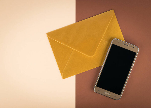 Gold smartphone with envelope on two color background