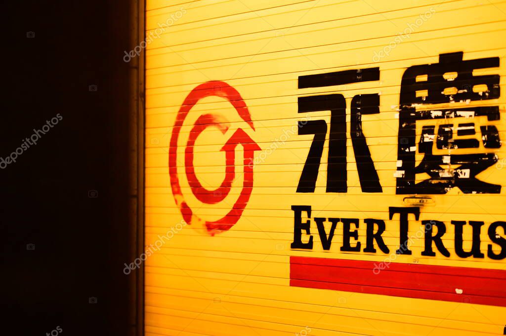 Taipei, Taiwan - Apr. 04, 2025: Authentic documentary photograph of EVERTRUST real estate agency sign featuring red spiral arrow logo and bilingual Chinese-English branding in Taiwan.