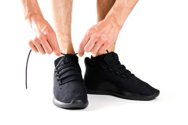 Siyah ayakkabı bağı bağlayan bir erkek spor ayakkabıları. Spor için. Beyaz arka plan üzerinde izole.