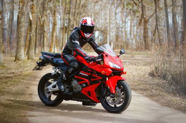 Krasnoyarsk, Rusya - 21 Nisan 2018: Güzel motosikletçi tam dişli ve bir kırmızı ve siyah Honda 2005 Cbr 600 Rr (Pc37 kask)