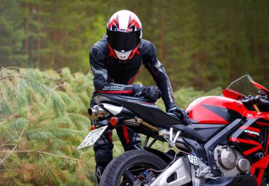 Krasnoyarsk, Rusya - 29 Mayıs 2018: Güzel motosikletçi tam Dişli ve bir kırmızı ve siyah Honda 2005 Cbr 600 Rr (Pc37 kask)