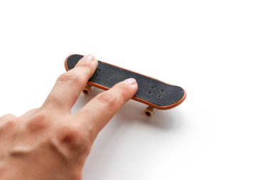 Klavye. Küçük bir kaykay ve bir el. Yakın çekim. Beyaz arka plan üzerinde izole