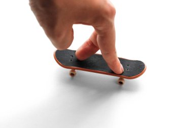 Klavye. Küçük bir kaykay ve bir el. Yakın çekim. Beyaz arka plan üzerinde izole