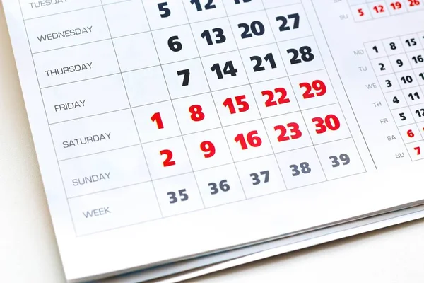 White calendar. Weekends are highlighted in red. Close up