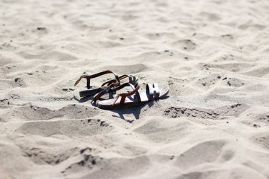 Sahil kumu üzerinde deri kahverengi flip flop