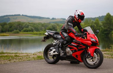 Krasnoyarsk, Rusya - 17 Temmuz 2018: Güzel motosikletçi tam Dişli ve bir kırmızı ve siyah Honda 2005 Cbr 600 Rr (Pc37 kask)