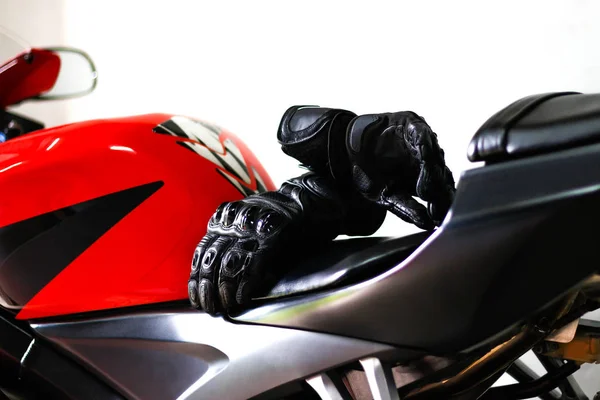 Schwarze Motorradhandschuhe Aus Leder Liegen Auf Einem Roten Sportfahrrad — Stockfoto