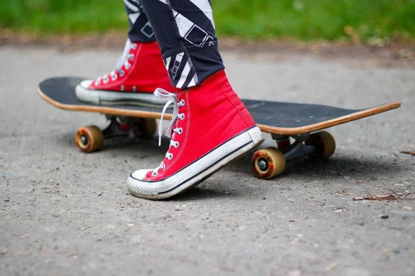 Meisje Rode Sneakers Een Skateboard Voeten Een Skateboard — Stockfoto