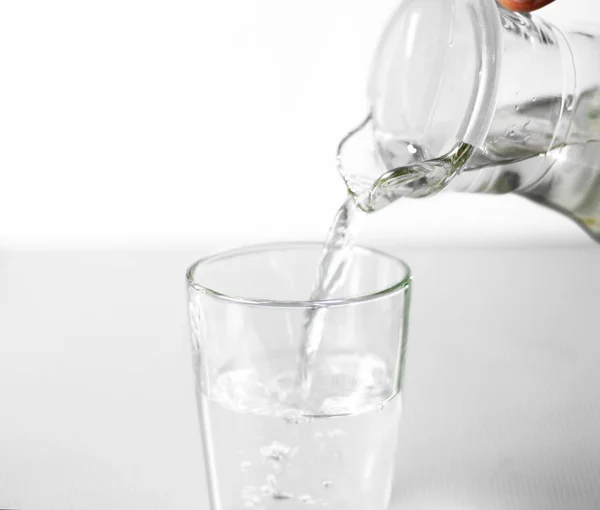 Hand Häller Vatten Ett Glas Glas Kopp Från Glaskanna Närbild — Stockfoto