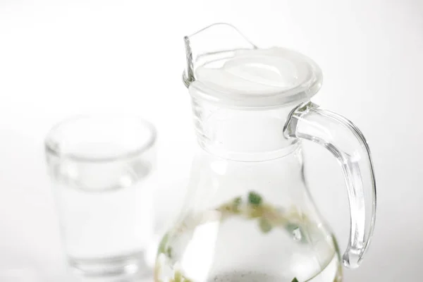 stock image Glass jug with water and glass Cup. Close up. Isolated on white background.