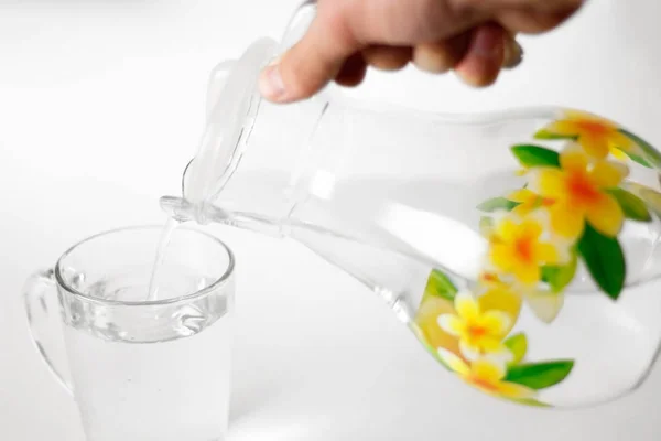 Mano Versa Acqua Una Tazza Vetro Una Brocca Vetro Chiudete — Foto Stock