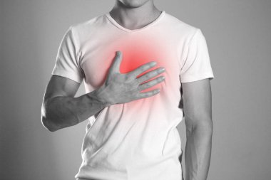 The man is holding his chest. Chest pain. Heartburn. The hearth is highlighted in red. Close up. Isolated background. clipart