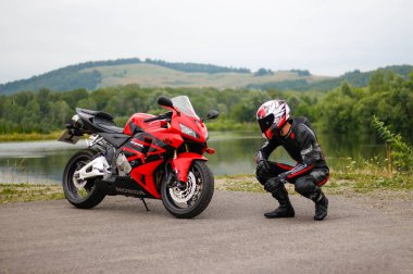 Krasnoyarsk, Rusya - 28 Haziran 2018: Güzel motosikletçi tam Dişli ve bir kırmızı ve siyah Honda 2005 Cbr 600 Rr (Pc37 kask)