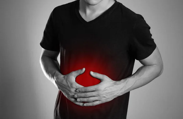 Hombre Sostiene Estómago Dolor Abdominal Hogar Está Resaltado Rojo Cerca — Foto de Stock