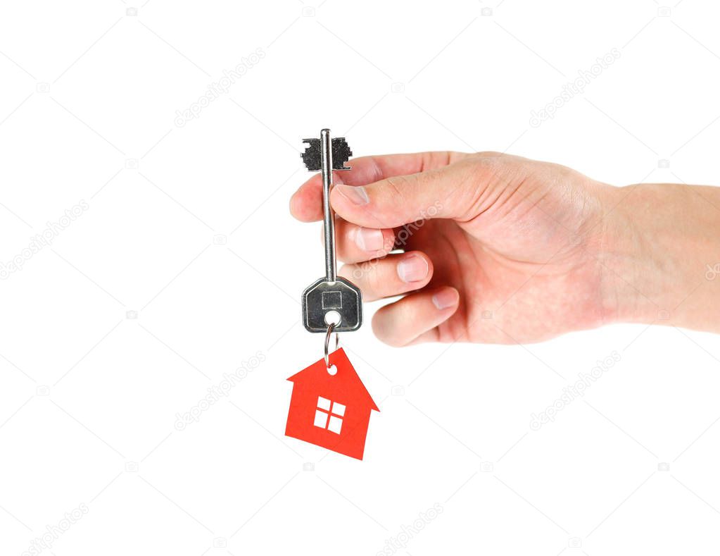 Hand holding the key to the house. Close up. Isolated on white background.