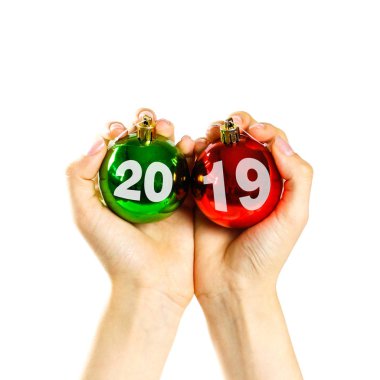Bir Noel top 2019 tarafından yazıldı. Noel top holding eller. Birçok Noel topları arka plan üzerinde. Çok Noel ağacı süsleri. Renkli cam toplar. Beyaz bir arka plan üzerinde izole.
