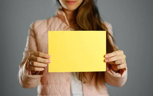 Uma Mulher Com Uma Jaqueta Inverno Quente Segurando Folheto Amarelo — Fotografia de Stock