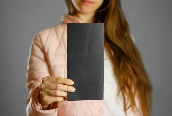 Una Mujer Con Una Cálida Chaqueta Invierno Sosteniendo Folleto Negro — Foto de Stock