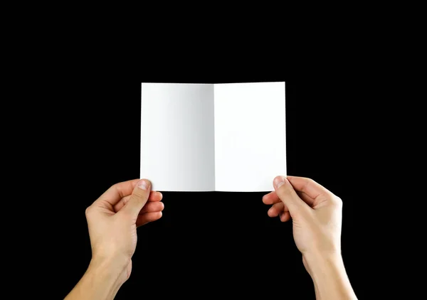 Mano Sosteniendo Folleto Blanco Folleto Mano Aislado Sobre Fondo Negro — Foto de Stock