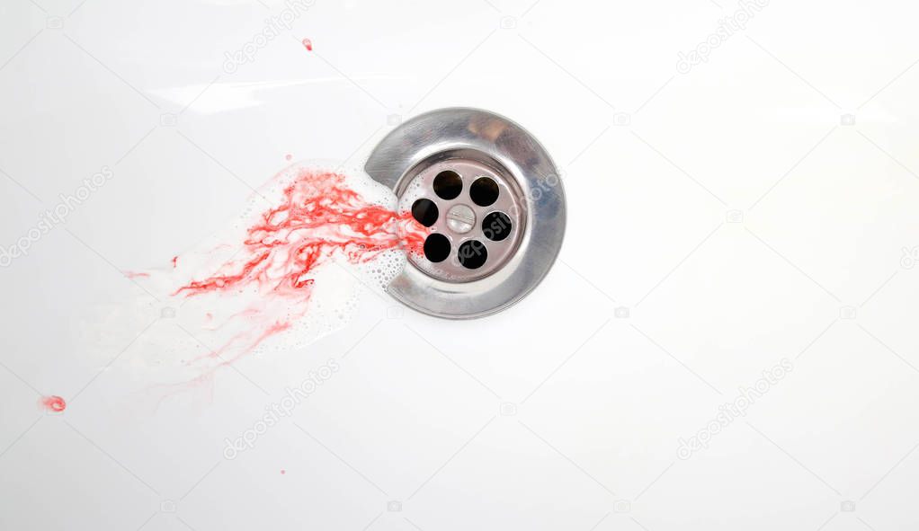 Toothpaste with blood in a ceramic sink. Bleeding gums. Close up.