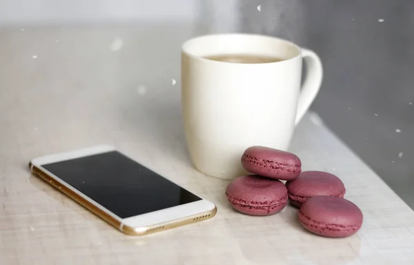 Eine Weiße Tasse Tee Und Lila Makronen Und Ein Smartphone — Stockfoto