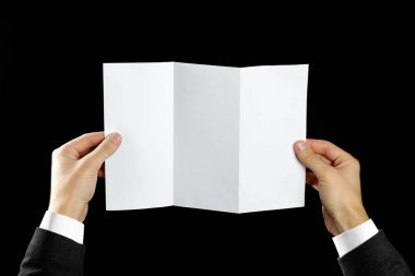 Boş broşür kitapçık elinde tutan el. Siyah arka plan üzerine izole. Adam gösterisi Kağıt Ofset. Sayfa şablonu. Elinde kitap. Kitapçık Katlama tasarım. Okuyun kağıt sayfası göstermek kat.