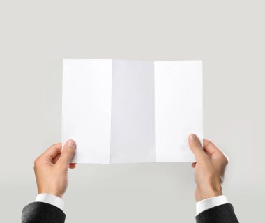Beyaz gömlek ve siyah ceket boş broşür kitapçık elinde tutan ellerinde. Broşür sunumu. Broşür elini adam. Adam gösterisi Kağıt Ofset. Sayfa şablonu. Elinde kitap. Kitapçık Katlama tasarım.