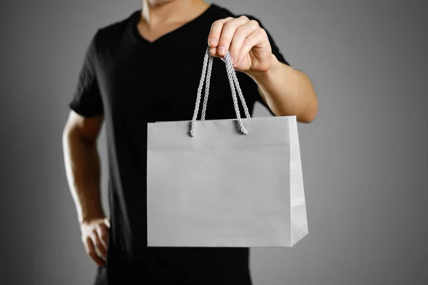 Man holding a gift bag. Close up. Isolated on grey background.