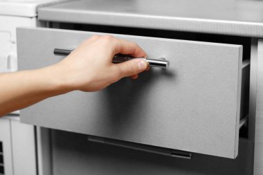 El mutfak dolap açar. El mutfak takımı kapısını kapatır. Yakın çekim.