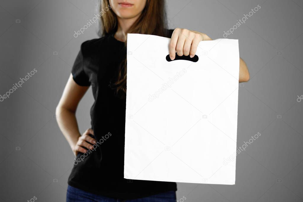 Girl holding a white plastic bag. Close up. Isolated background.