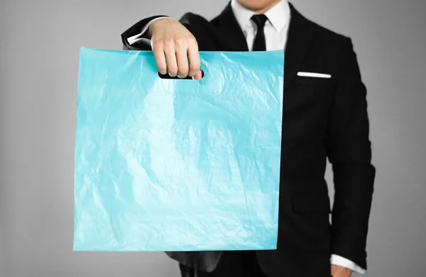 Бизнесмен Черном Костюме Держит Синий Пластиковый Пакет Закрывай Изолированный Фон — стоковое фото