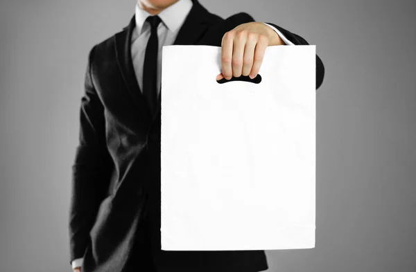 Podnikatel Černém Obleku Drží Bílý Plastový Sáček Zblízka Izolované Pozadí — Stock fotografie