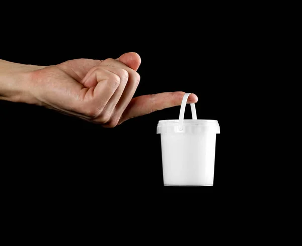 Hand holding a small white bucket. Close up. Isolated on white background.