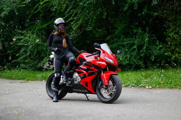 KRASNOYARSK, RUSSIA - 2018 년 6 월 23 일: 빨간색과 검정 색혼다 2005 CBR 600 RR (PC37) 에 장비와 헬멧을 착용 한 아름다운 소녀 오토바이). — 스톡 사진