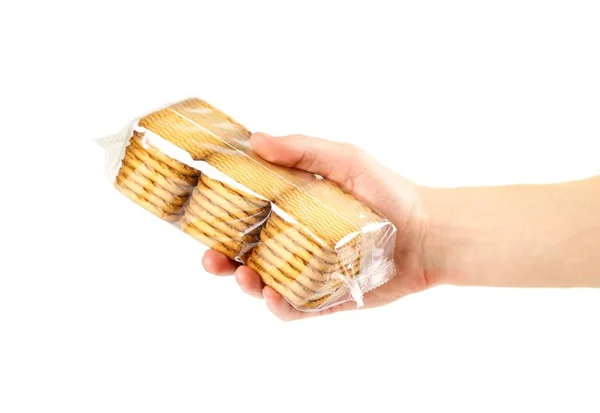 Hand hält einen goldenen Keks in einer durchsichtigen Verpackung. Nahaufnahme. — Stockfoto