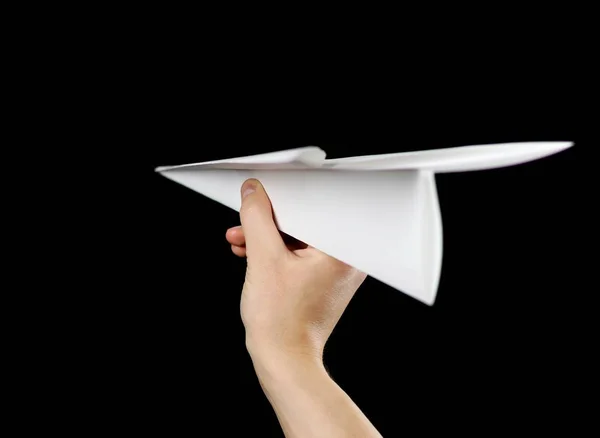 Mão segurando um avião de papel branco. Fecha. Isolado em preto — Fotografia de Stock