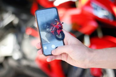 Telefon kamera spor kırmızı motosiklet üzerinde el fotoğraf çekmek