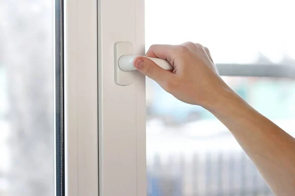 A mão de um homem abre uma janela de plástico branco. Fechar — Fotografia de Stock