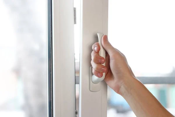 Το χέρι ενός άντρα ανοίγει ένα λευκό πλαστικό παράθυρο. Κοντινό — Φωτογραφία Αρχείου